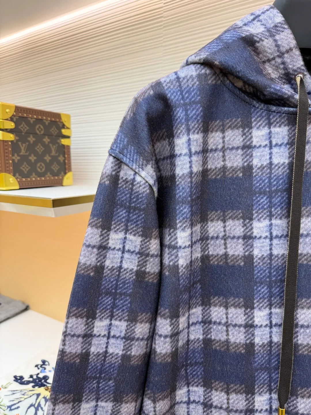 LOUIS VUITTON plaid gradient long-sleeved hoodie ●Original version: Purchased and developed for 15100 ●Item number: 1681896-B40 ●Fabric: wool blended fabric ●Technology: Digital direct printing ●Color: Purple ●Version: Fitted version ●Weight: about 1035 grams ●Size: S-M-L-XL ●Description: This hooded sweatshirt uses splicing technology to create a layered texture: the upper part is made of wool blended fabric with a blue and gray plaid pattern, and is pre-shrunk to ensure a stable fit; the lower part and sleeves use digital printing technology to present a gradient Monogram dark pattern, and the ink penetrates the fiber to achieve high color fastness. The hood has a built-in invisible lining to enhance stiffness, and the drawstring is made of wear-resistant nylon rope with a metal bell for smooth pulling. The front kangaroo pocket is made of welted bag technology, and the edge of the bag mouth is reinforced with double stitching. The cuffs and hem are made of ribbed knitted fabric, and the elastic hemming fits the body shape. The seams throughout the garment are high-strength stitches of the same color. Precision sewing every 3cm/12 stitches improves durability. The overall craftsmanship takes into account both visual details and practical durability. The overall wiring is straight and delicate, the fabric is comfortable and soft, and the color is consistent without color difference. It can be matched with the same style to create a fashionable look and control various occasions. Customized accessories, complete with three standards, same style for men and women!